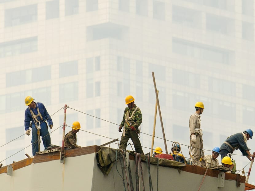 Labourers work on a smoggy day in Beijing. AP file photo