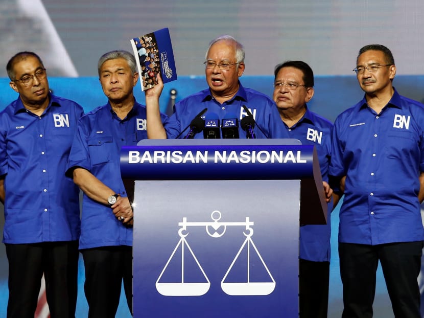 Prime Minister Najib Razak holds up a booklet on BN's manifesto during its launch on April 7 alongside other coalition leaders.