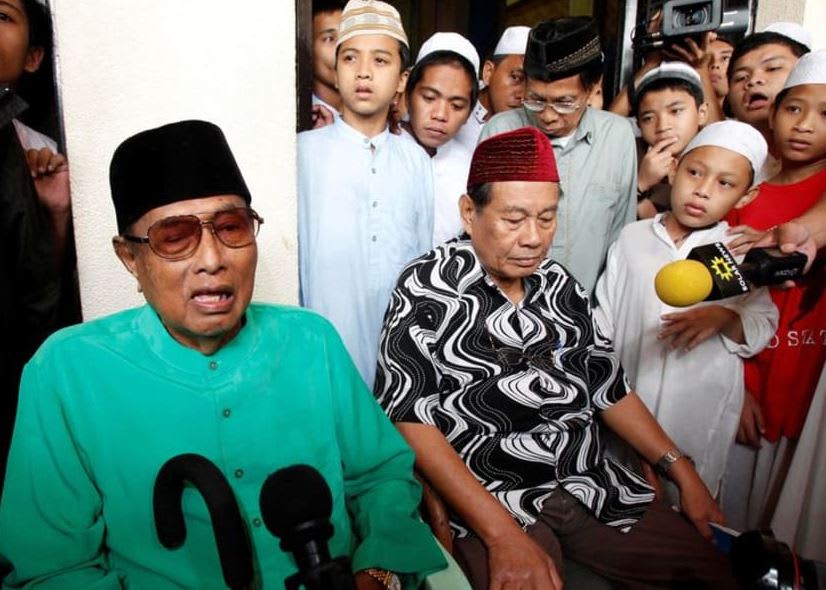 (left) Jamalul Kiram III, a former Sultan of the Sulu region of the southern Philippines, answers questions as he sits surrounded by his followers, during a brief news conference in front of the Blue Mosque in Taguig city, south of Manila on Feb 22, 2013. 