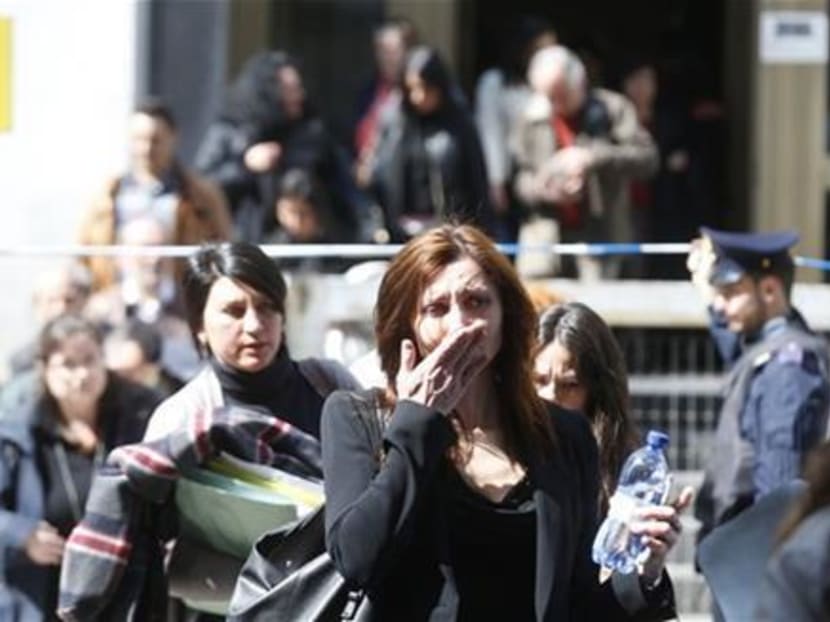 A woman cries as she is evacuated from the tribunal building in Milan, Italy, after a shooting was reported inside a courtroom on Thursday, April 9, 2015. Photo: AP