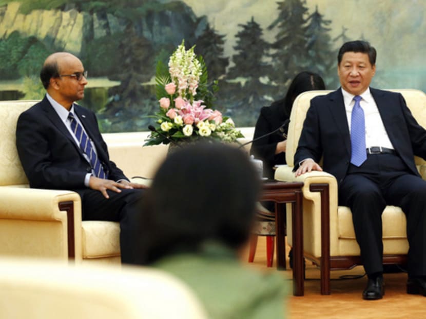 China's President Xi Jinping (R) meets with the guests at the Asian Infrastructure Investment Bank launch ceremony at the Great Hall of the People in Beijing October 24, 2014. On the left is Singapore's Deputy Prime Minister and Finance Minister Tharman Shanmugaratnam. REUTERS/Takaki Yajima/Pool (CHINA - Tags: BUSINESS POLITICS)