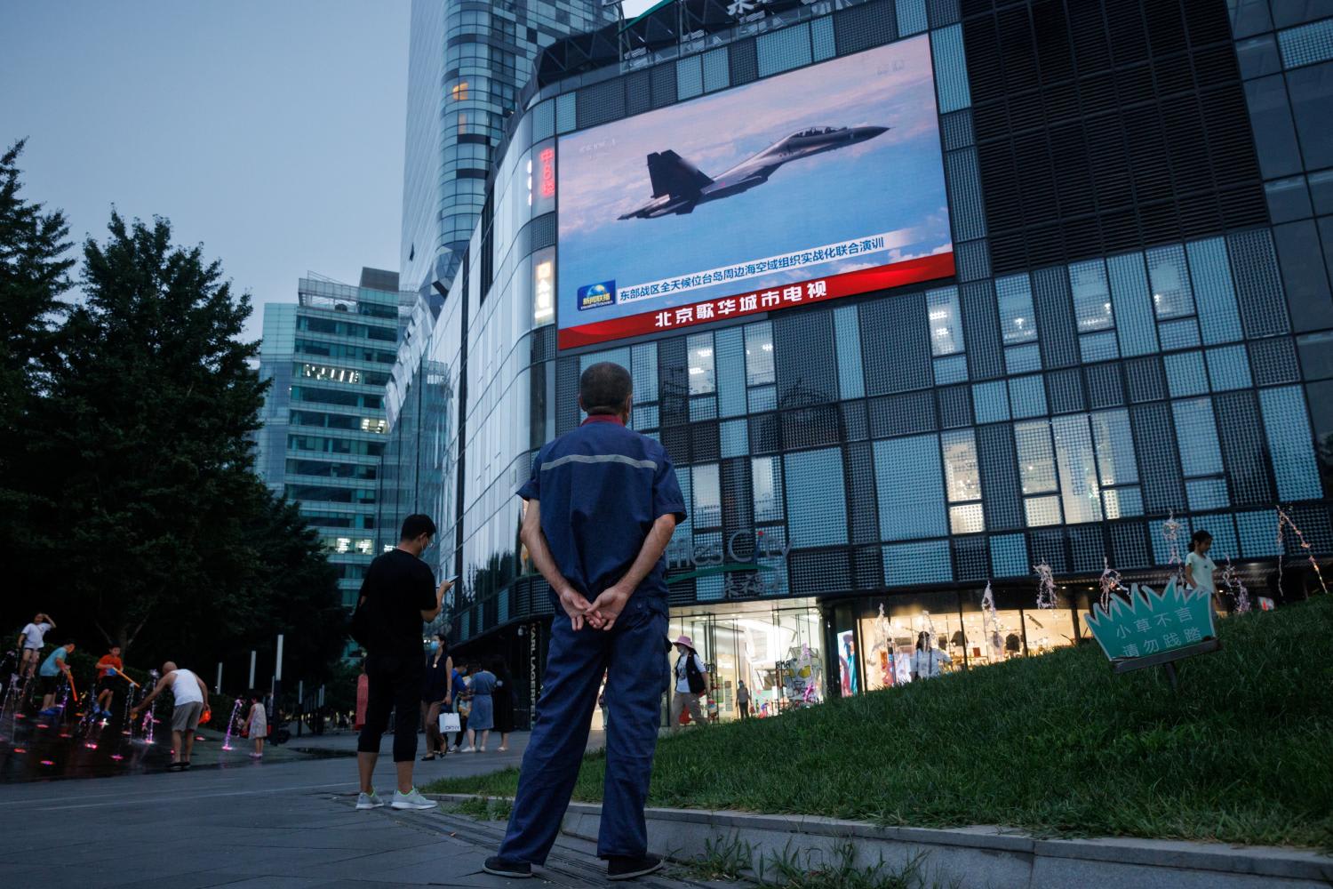 A man in Beijing watches a news broadcast showing a fighter jet during joint military operations near Taiwan on Aug 3, 2022.
