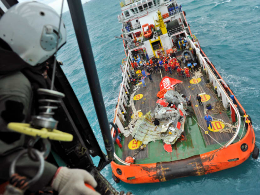 In this photo taken from an Indonesian Air Force Super Puma helicopter, the tail part of AirAsia QZ 8501 is seen on the deck of rescue ship after it was recovered from the sea floor on the Java Sea, Saturday, Jan. 10, 2015. Investigators searching for the crashed AirAsia plane's black boxes lifted the tail portion of the jet out of the Java Sea on Saturday, two weeks after it went down, killing all 162 people on board. Photo: AP