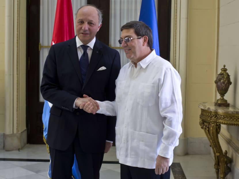Cuba's Foreign Minister Bruno Rodriguez, right, and France's Foreign Minister Laurent Fabius shake hands toward photographers prior to their meeting at the Foreign Ministry in Havana, Cuba, Saturday, April 12, 2014. Photo: AP