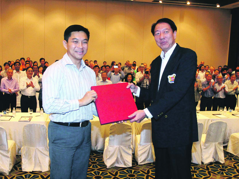 New SNOC president Tan Chuan-Jin (left) giving a photo book to DPM Teo Chee Hean. Photo: Ernest Chua