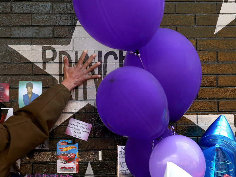 A mourner and fan touches the star for Prince on a wall at First Avenue where the singer often performed, Saturday, April 23, 2016, in Minneapolis. The pop superstar died Thursday at the age of 57. Photo: Star Tribune via AP