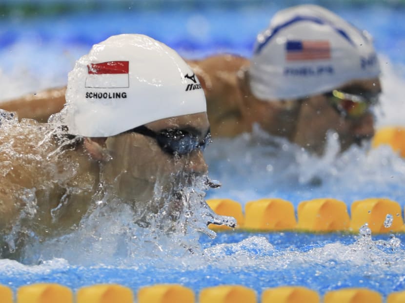 Joseph Schooling (left) competes alongside Michael Phelps in the 100m butterfly heats. Photo: Reuters