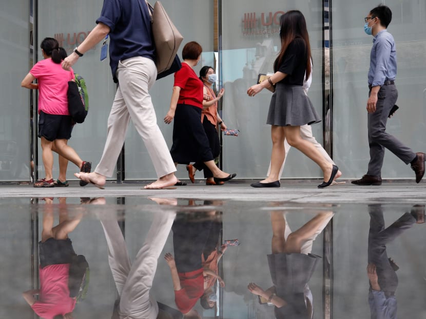 Office workers wearing protective face masks walk in the central business district during the Covid-19 outbreak in Singapore.