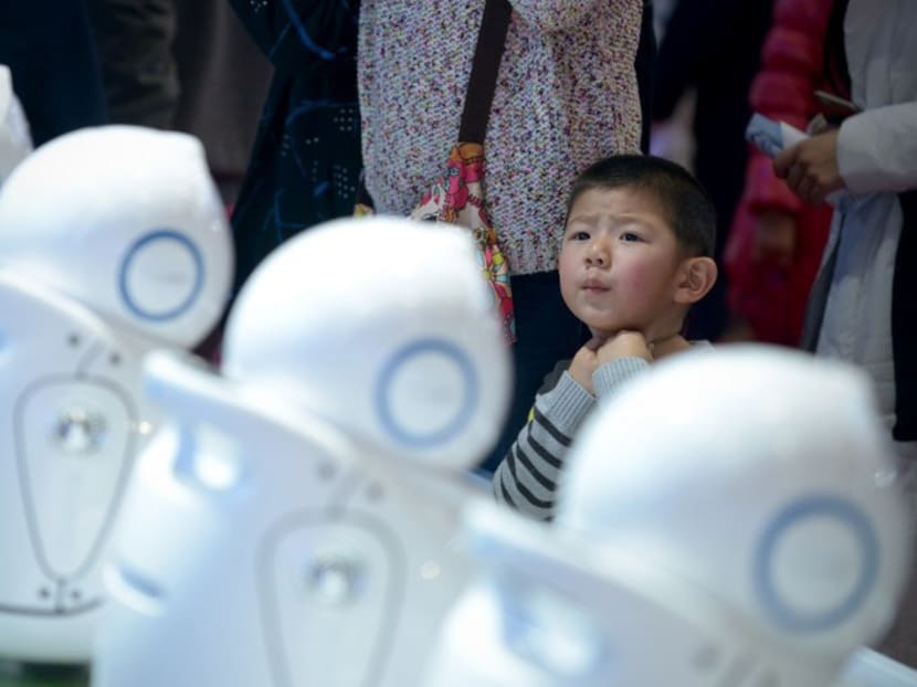 A boy looking at a display of robots during the World Robot Conference in Beijing. AFP file photo