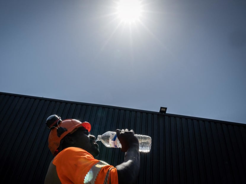 A worker drinks water in a construction site in Savenay, outside Nantes, on July 18, 2022, as a heatwave hits France. 