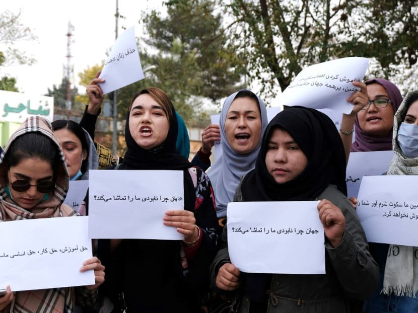 Women hold placards during a protest in Kabul on Oct 26, 2021, calling for the international community to speak out in support of Afghans living under Taliban rule.