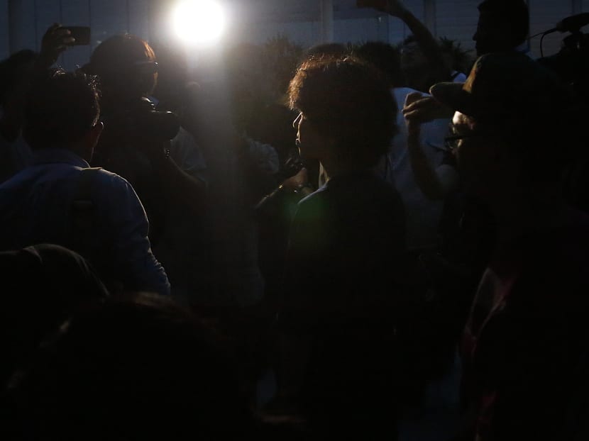 Blogger Amos Yee (centre) is followed by media while leaving the Subordinate Courts after being released on bail on May 12, 2015. Photo: AP