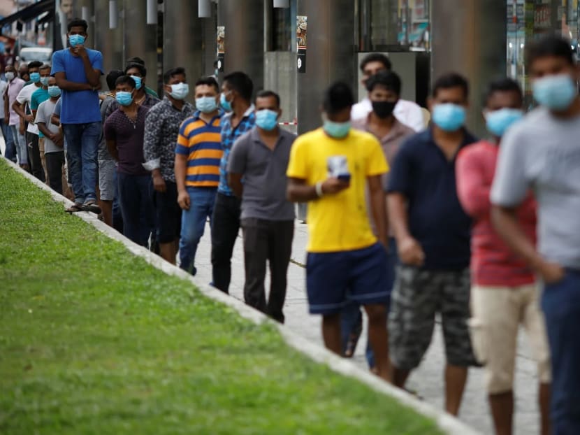 Migrant workers wait for volunteers from the Alliance of Guest Workers Outreach to distribute free meals in the Little India district of Singapore.