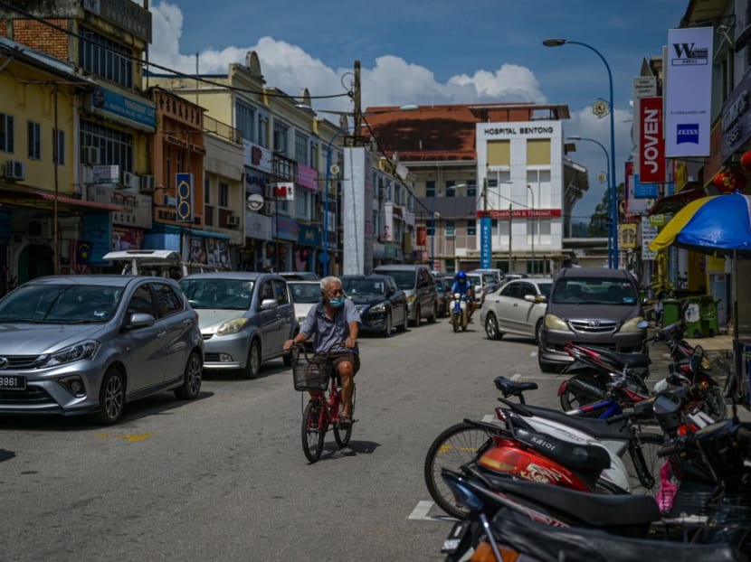 A man rides a bicycle past shophouses in Bentong in Malaysia's Pahang state on Jan 29, 2021.