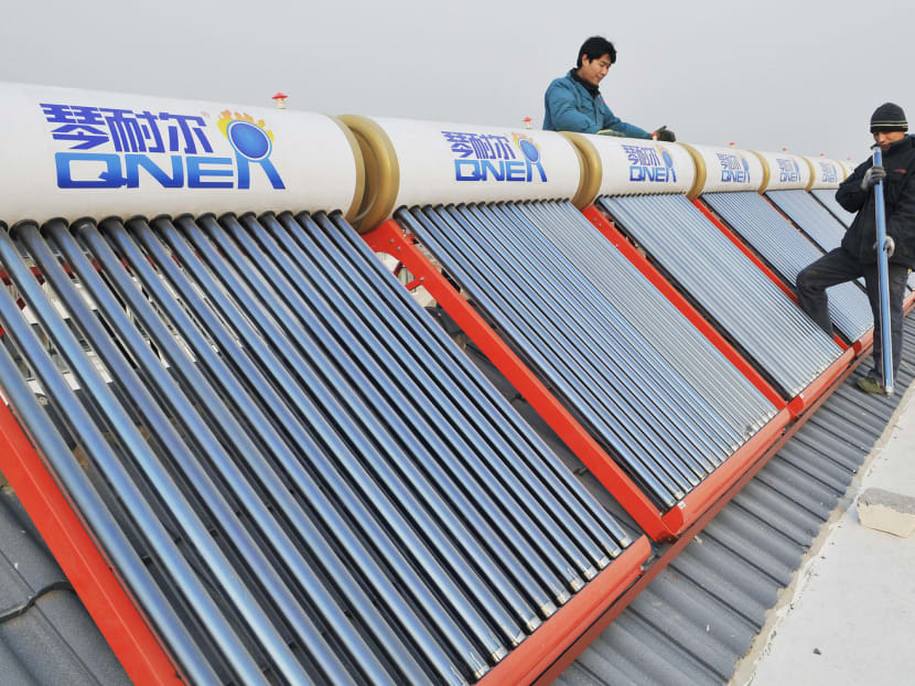 A worker examining solar water heaters on the roof of a residential building in Rizhao, Shandong province. Rooftop solar accounted for just 17 per cent of China’s installed solar capacity in 2014, way below Germany’s 70 per cent. Photo: Reuters