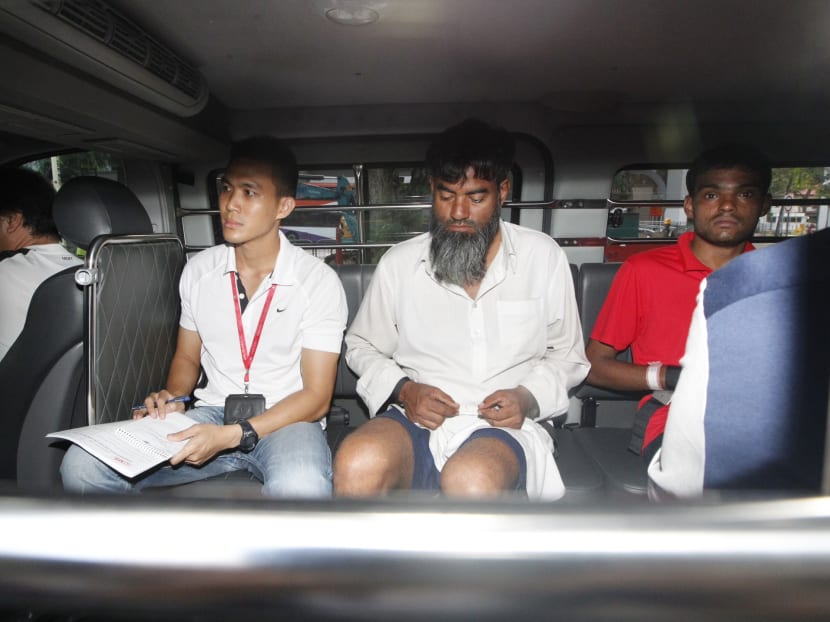 Ramzan Rizwan, 25, in red, and Rasheed Muhammad, 43 (second from right facing camera) arrive at the State Courts on June 14, 2014 to be charged for murder in the case of a legless body found in Syed Alwi Road. Photo: Don Wong