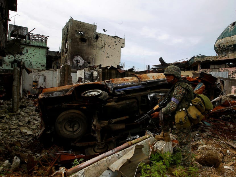 A government soldier from Philippine Marines 1st Brigade patrols past damaged buildings as troops continue their assault on clearing operations against the pro-Islamic State militant group in Marawi city, southern Philippines, September 14, 2017. Photo: REUTERS