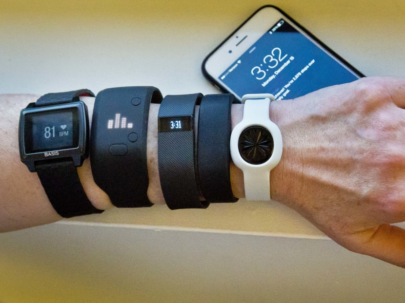 In this Dec 15, 2014, file photo, fitness trackers, from left, Basis Peak, Adidas Fit Smart, Fitbit Charge, Sony SmartBand, and Jawbone Move, are posed for a photo next to an iPhone, in New York. Photo: AP
