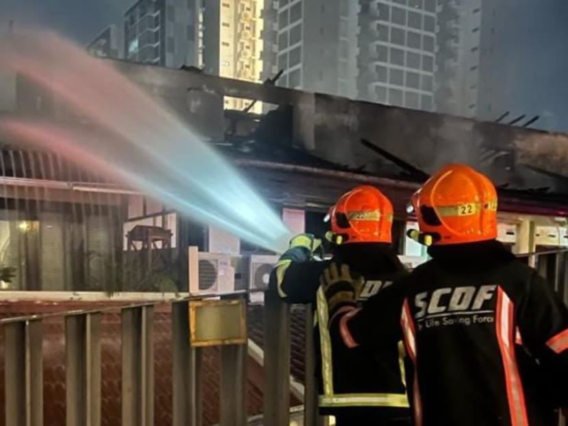 Firefighters conducting dampening down operations at affected houses along East Coast Road after a blaze on Jan 10, 2023.