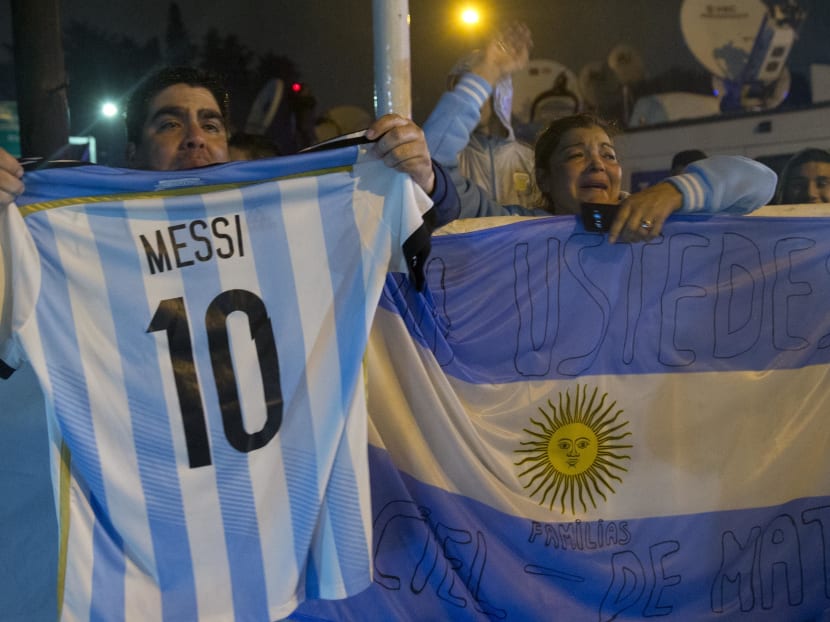A fans holds an national soccer team jersey with the name and number of Lionel Messi as the bus with the national team arrives to the Argentina Soccer Association, Monday, June 27, 2016, in Buenos Aires, Argentina. Photo: AP