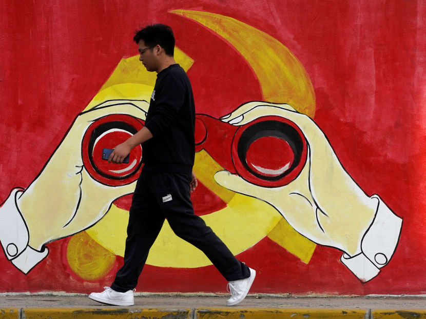 A man walks next to a mural showing an image of the Chinese Communist Party's emblem along a street in Shanghai on Sept 25.