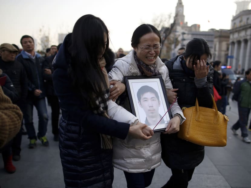 A woman holds a photo of her son who died in the New Year's Eve stampede on the Bund in Shanghai, January 2, 2015. Chinese state media and the public criticised the government and police on Friday for failing to prevent the stampede in Shanghai that killed 36 people and dented the city's image as modern China's global financial hub. Photo: Reuters