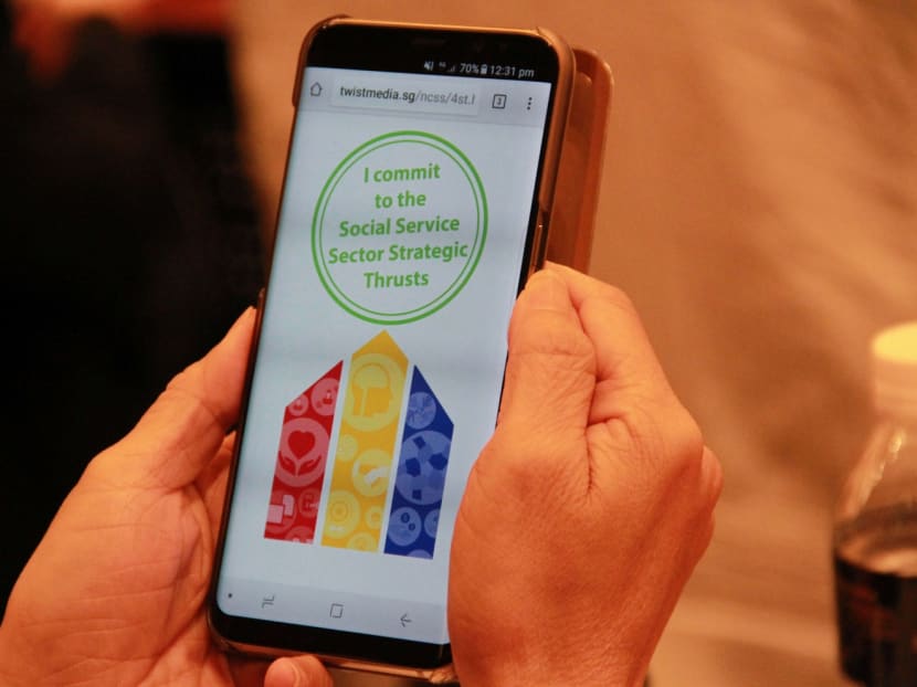 A participant committing to the Social Service Sector Strategic Thrusts (4ST), a 5 year roadmap for the sector co-developed by NCSS with Stakeholders in the social service ecosystem, at the NCSS Social Service Summit on July 5, 2017. Photo: Esther Leong/ TODAY