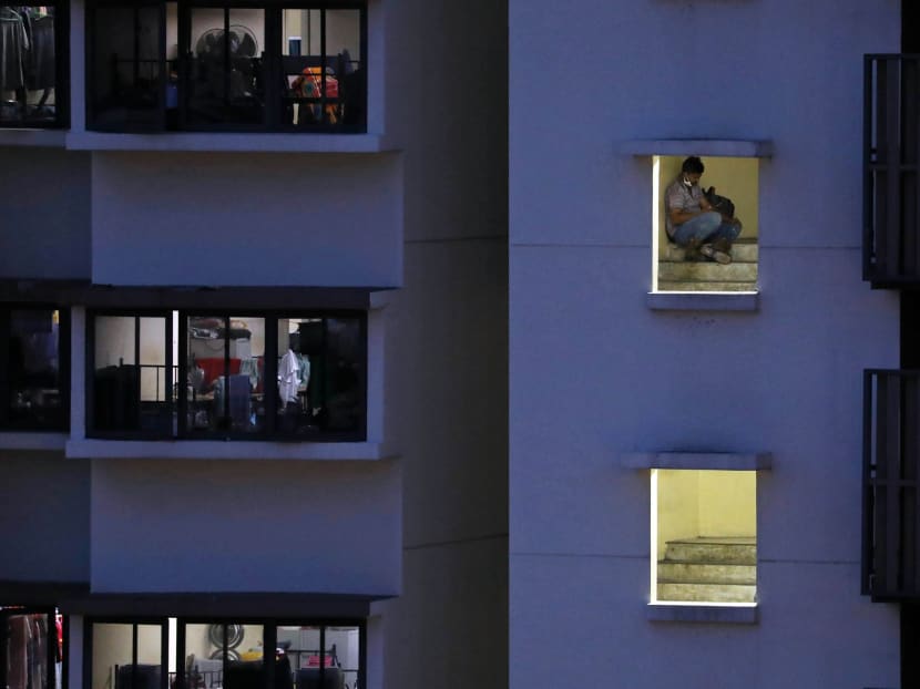 A migrant worker uses his phone at a dormitory block in Toh Guan on July 15, 2021. Unlike the wider community, migrant workers residing in dormitories have been largely confined to their rooms and worksites over the past 15 months.