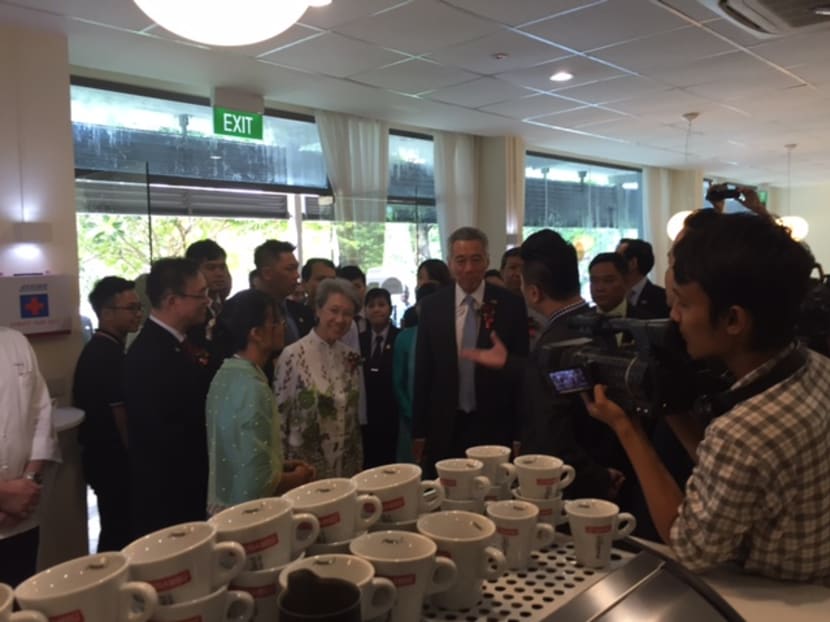PM Lee touring the new premises of the Singapore-Myanmar Vocational Training Institute, which have set ups such as cafes, for students to practise their skills. Photo: Tan Weizhen/TODAY