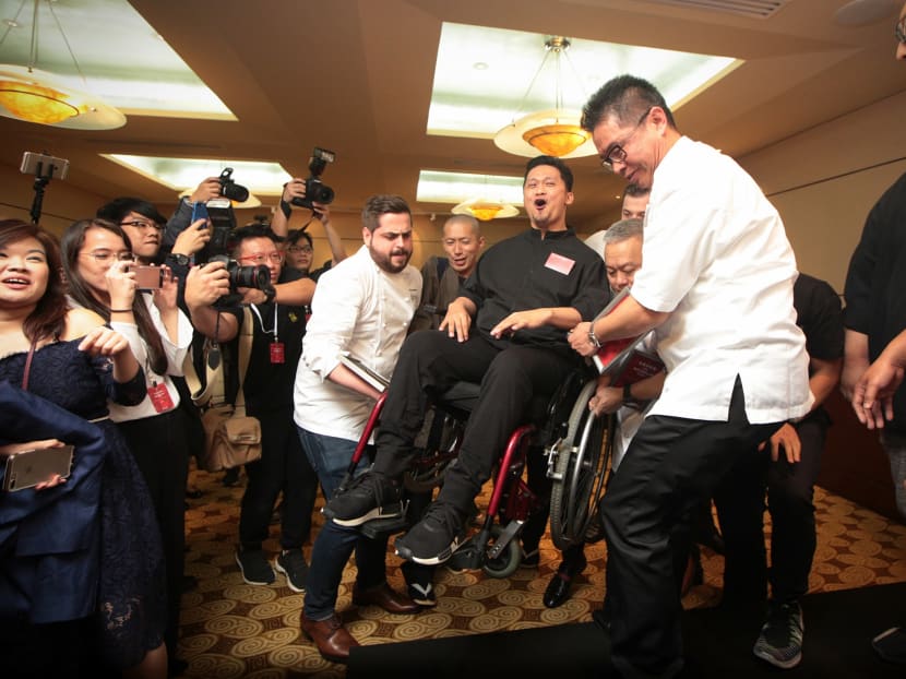 Chef Haikal Johari of Alma reacts as he is helped by other one-star Michelin recipients on stage for a group photo, at the Michelin guide Singapore 2017 star event. Photo: Jason Quah/TODAY