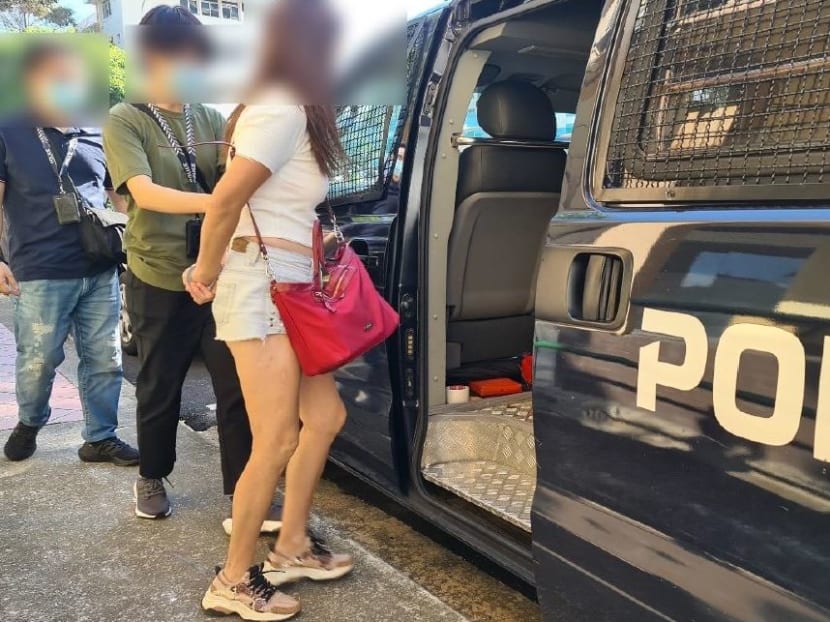 A woman is seen being led into a police vehicle after an enforcement check was conducted at an unlicensed massage establishment along Balestier Road. 