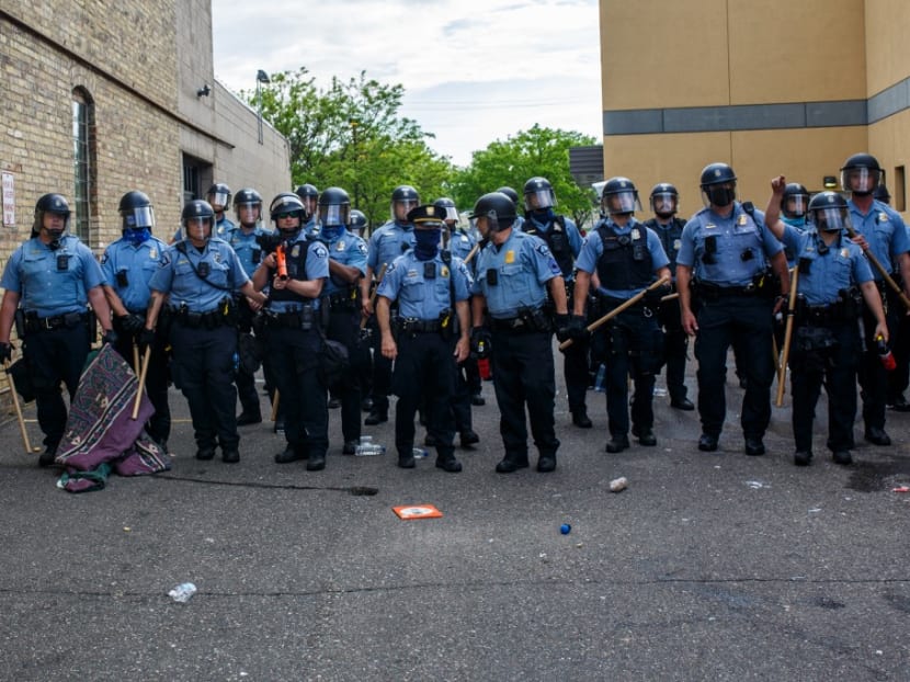 Minneapolis police officers stand in a line while facing protesters demonstrating against the death of George Floyd outside the 3rd Precinct Police Precinct in Minneapolis, Minnesota, on May 27, 2020.