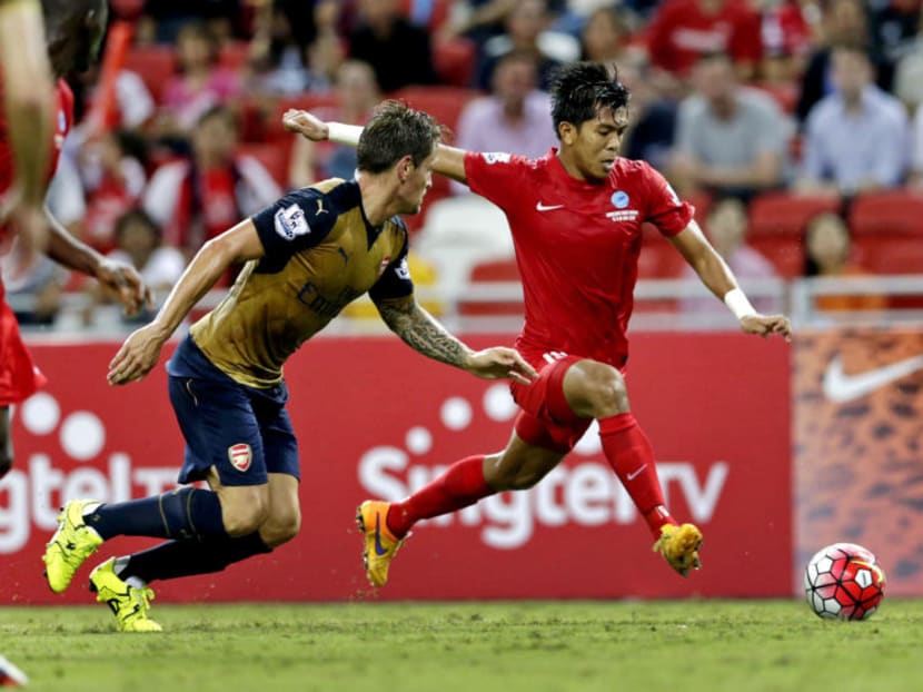 Singapore Select XI striker Khairul Amri (in red) trying to get the better of Arsenal's Mathieu Debuchy when the two sides met at the 2015 Barclays Asia Trophy in Singapore. TODAY FILE PHOTO