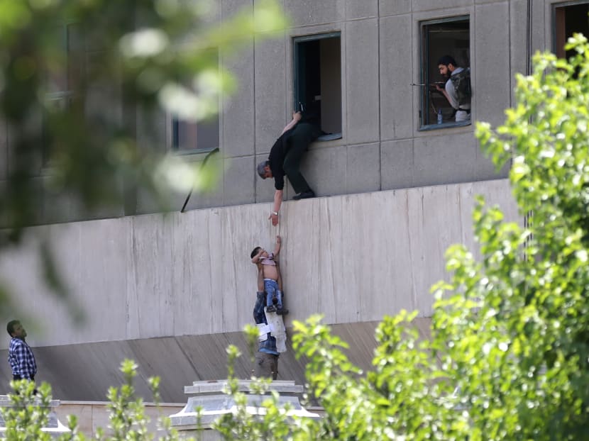 Iranian policemen evacuate a child from the parliament building in Tehran on June 7, 2017 during an attack on the complex.  Photo: Fars News via AFP