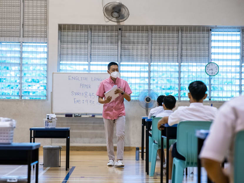 An invigilator distributes the examination papers in the examination venue for students taking leave from quarantine. An invigilator distributes the examination papers in the examination venue for students taking leave from quarantine.