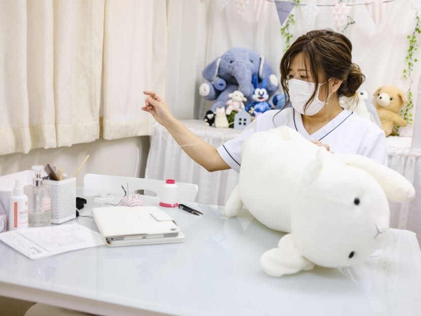 Natsumi Clinic Founder Natsumi Hakozaki working on client Yui Kato's stuffed toy sheep in Toyko. The clinic specialises in restoring much-loved teddies and other cuddly toys to their original glory, delighting deeply attached owners like Yui Kato.