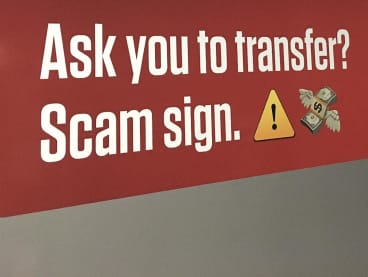 A sign at an MRT station warning people to beware of scams.