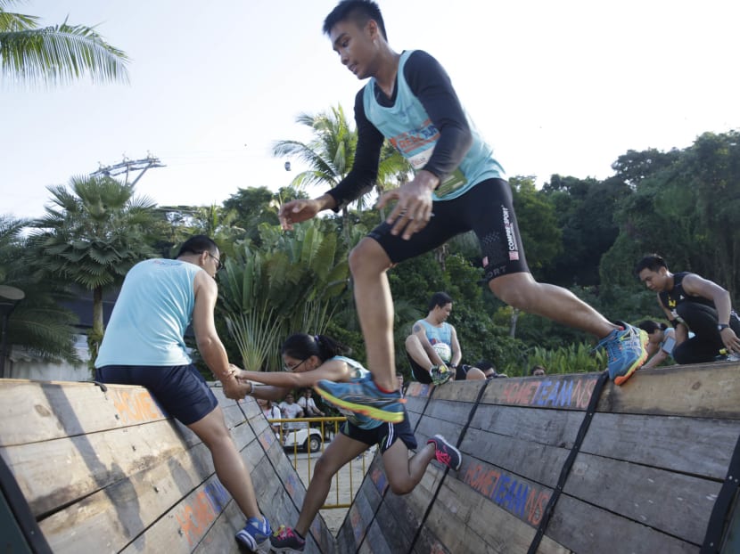 Participants trying the Multi-Terrain Obstacles Challenge at the HomeTeamNS REAL Run at Sentosa on Sunday. Photo: Wee Teck Hian