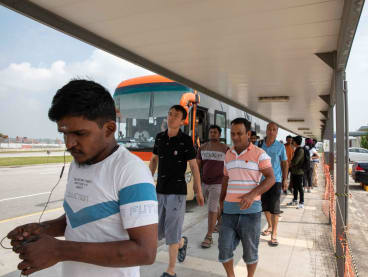 Migrant workers waiting to board a shuttle bus at Changi East Pass Office, near Tanah Merah Ferry Terminal, on Oct 1, 2023.