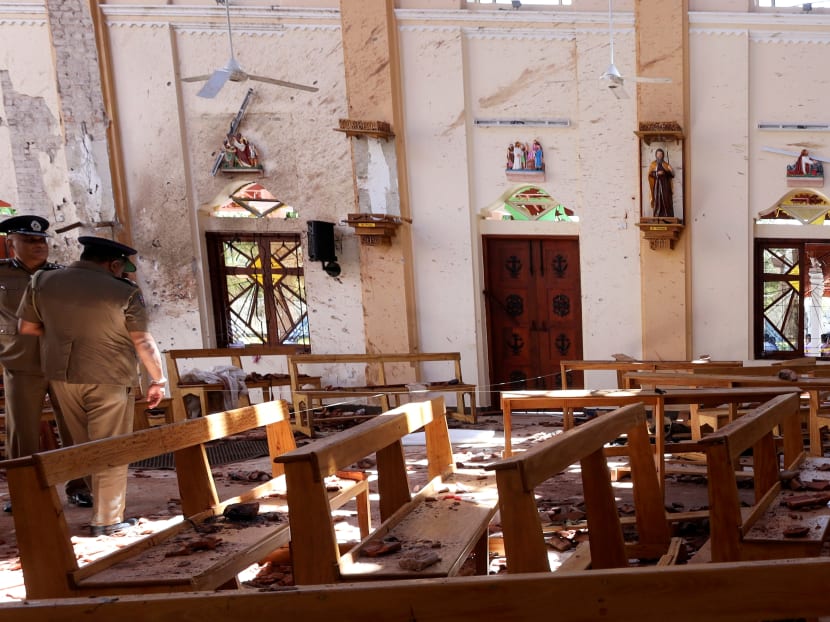 Police officers work at the scene at St. Sebastian Catholic Church, after bomb blasts ripped through churches and luxury hotels in Negombo, Sri Lanka on April 22.