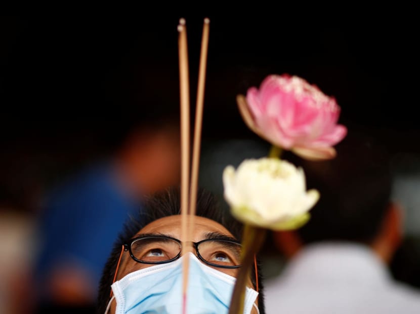 A man wearing a mask in precaution of the coronavirus outbreak prays at the Kwan Im Hood Cho Temple in Singapore February 19, 2020.