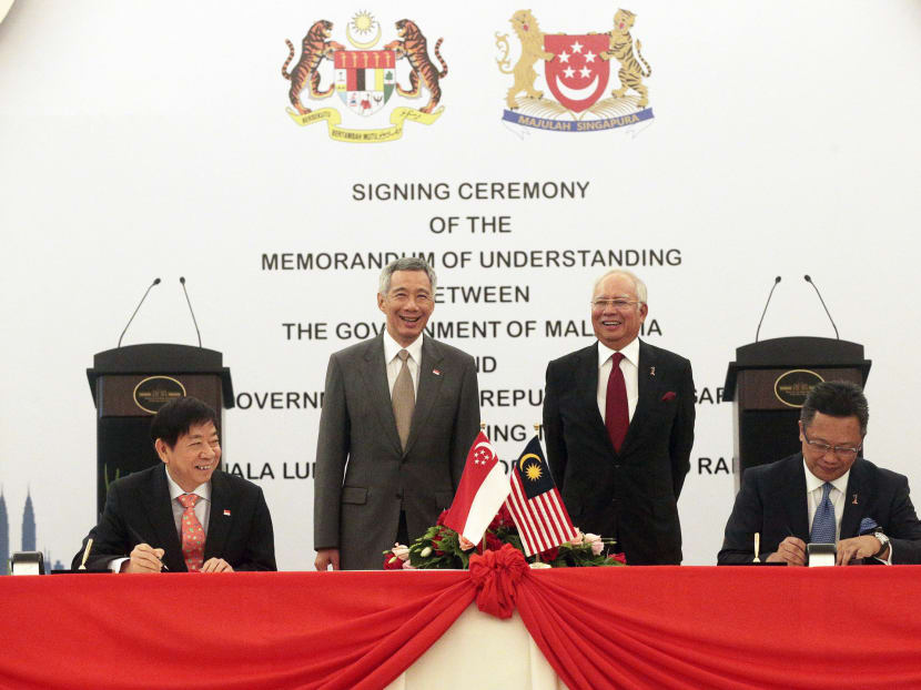 Singapore's Prime Minister Lee Hsien Loong and Malaysia's Prime Minister Najib Razak look on as Singapore's Transport Minister Khaw Boon Wan, and Malaysia's Minister in the Prime Minister's department Abdul Rahman Dahlan sign the HSR MOU in Putrajaya on July 19, 2016. Photo: Jason Quah