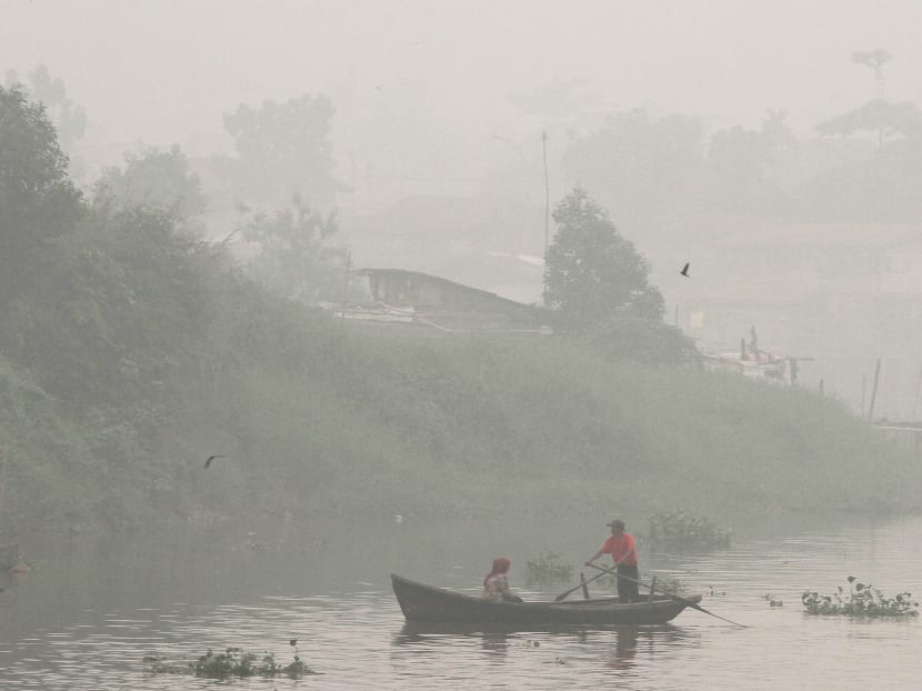A man rows a boat on Siak River as thick haze from wildfires blanket the city in Pekanbaru, Riau province, Indonesia, on Oct 5, 2015. The speedboat’s skipper said he was unable to see well when docking the vessel amid thick haze on Sunday morning. Photo: AP