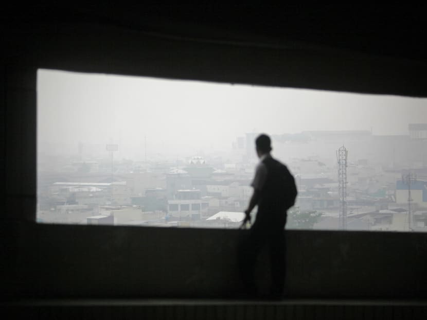 A man watches the skyline as haze from wildfires blanket the city Medan, North Sumatra, Indonesia, Tuesday, Oct. 6, 2015. Photo: AP
