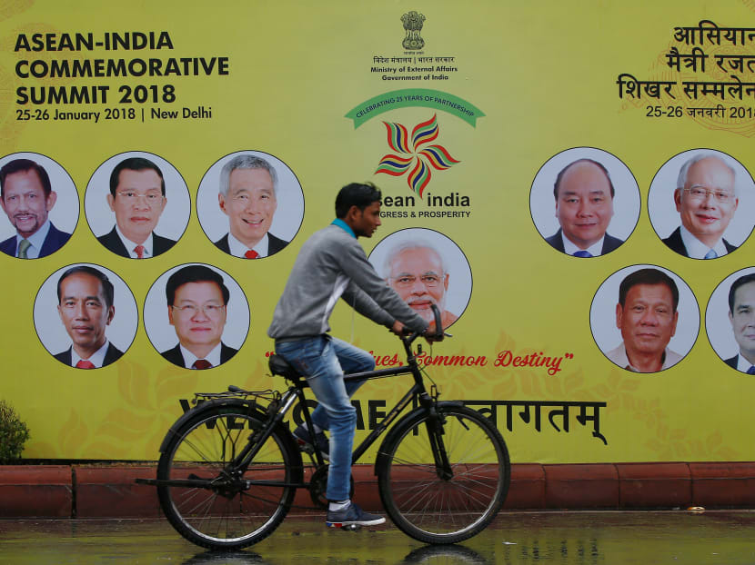 A cyclist rides past an Asean-India Commemorative Summit billboard the side of the road in New Delhi on Tues (Jan 23). Photo: Reuters