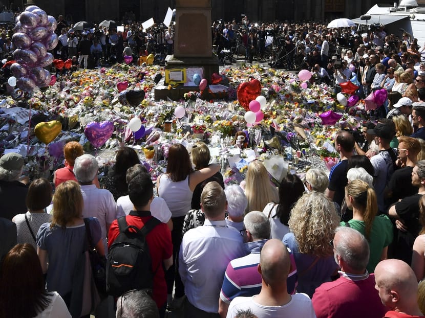 People stop to observe a minute's silence in St Ann's Square gathered around the tributes, in central Manchester, northwest England, on May 25, 2017, as a mark of respect to the victims of the May 22 terror attack at the Manchester Arena.  Photo: AFP