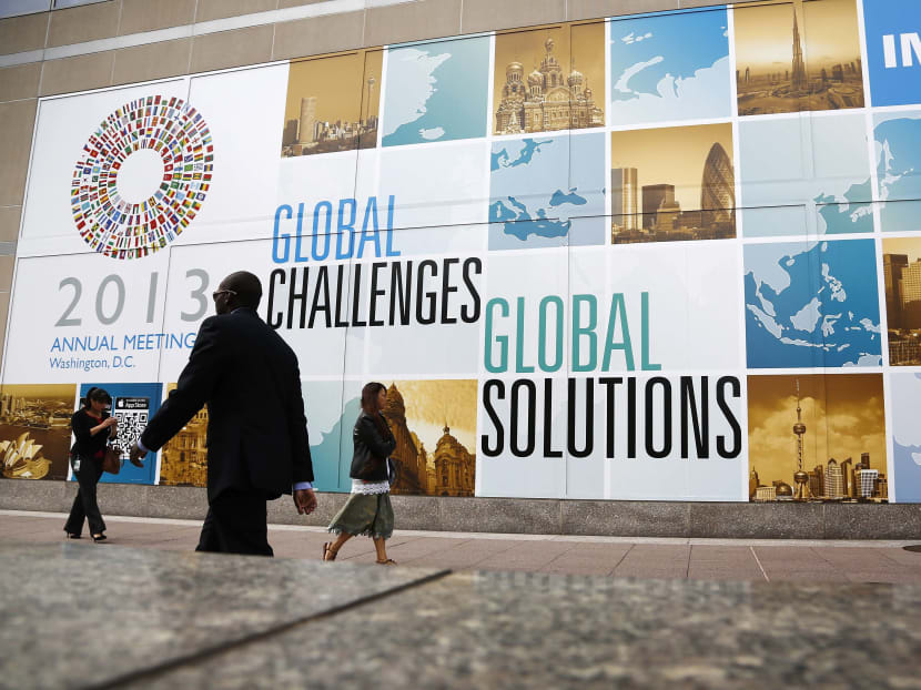 People walk outside the International Monetary Fund headquarters at the start of the annual IMF-World Bank fall meetings in Washington, October 8, 2013. Photo: Reuters