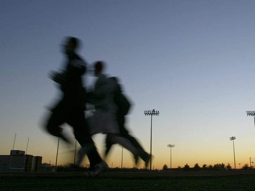 Students jog around a stadium at sunset in 2004, in Bowling Green, Kentucky. Photo: AP