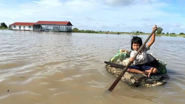 为了上学 柬埔寨女童划“垃圾船”渡湖