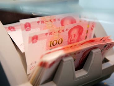 FILE PHOTO: Chinese 100 yuan banknotes are seen in a counting machine while a clerk counts them at a branch of a commercial bank in Beijing, China, March 30, 2016. REUTERS/Kim Kyung-Hoon/File Photo